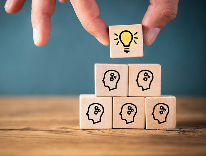 fingers stacking little blocks - top one with lightbulb