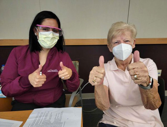 UCHealth worker and patient give thumbs up to camera