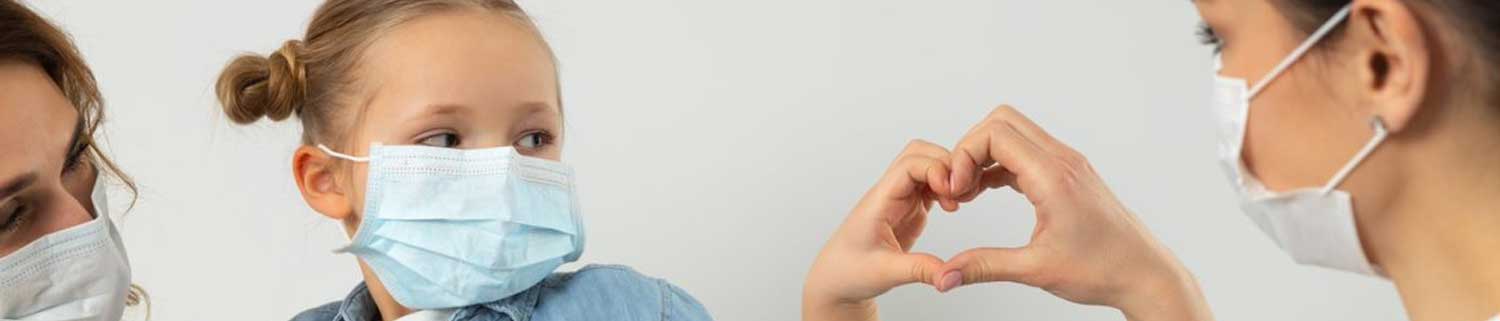 Child and nurse make a heart together with thier hands