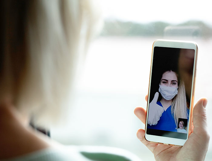Two people sitting down in an office. One is holding a folder with notes, and is listening to the other person.