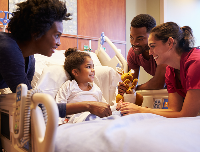 Child in hospital bed with medical staff