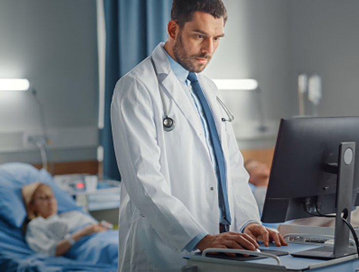Medical staff working on a computer in patients room