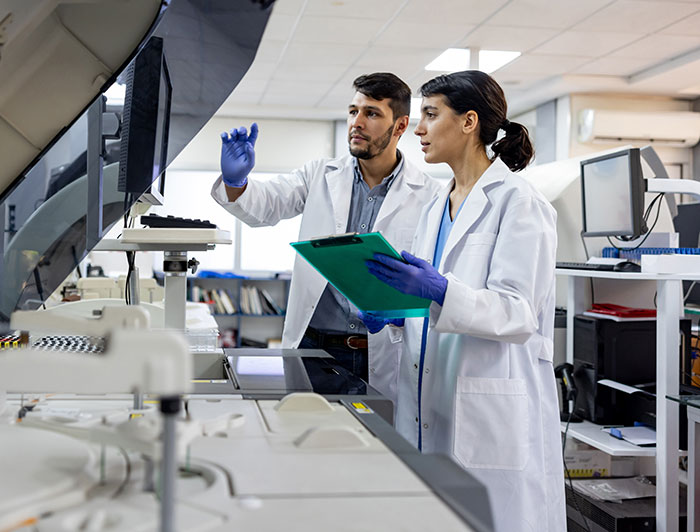 Kaiser Permanente Northern California. Stock image of scientists in lab coats holding clipboards