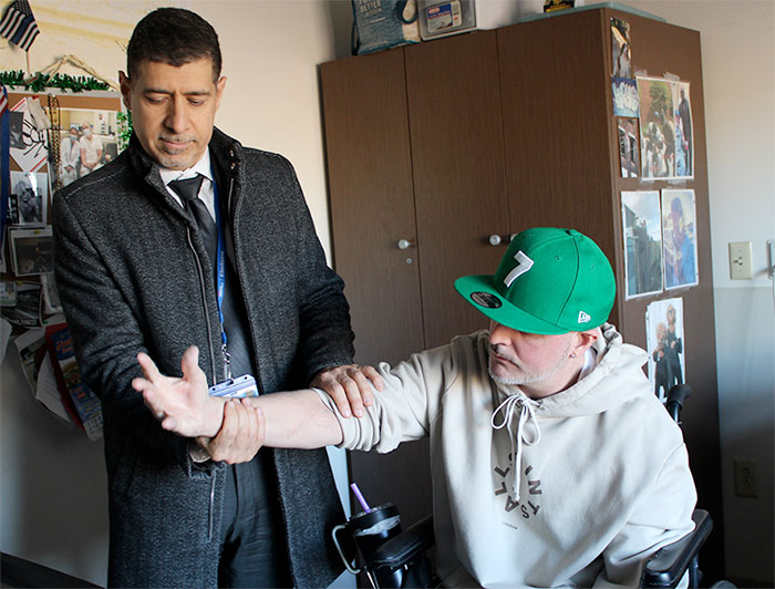 Eitan Melamed, M.D., chief of hand surgery at NYC Health + Hospitals, check's Harry Perks' right hand