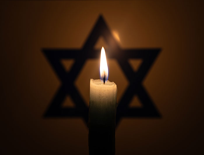 HCA Florida. A lit candle in front of a Star of David.