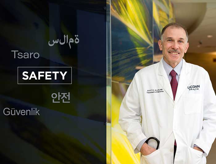 Scott Allen standing with the word SAFTEY in multiple languages