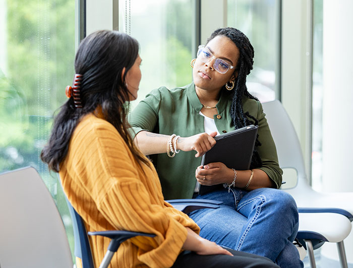 UVM Medical Center. A female counselor in casual attire sits holding a tablet and listening intently to a female patient