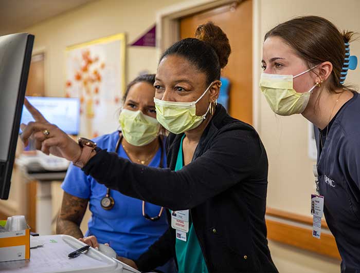 Medical Staff looking closley at something one is pointing to on a monitor