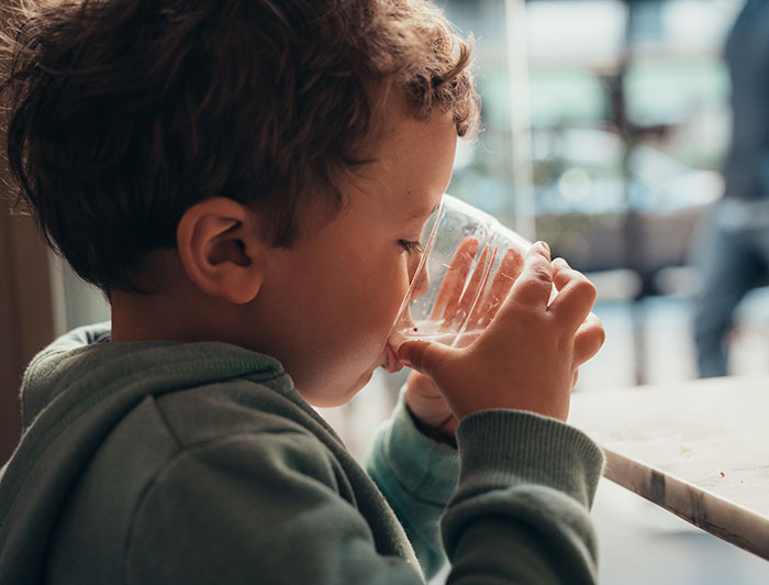 Arkansas Children's Hospital. A toddler drinks water from a cup