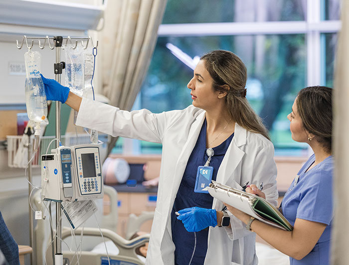 Avera Health. A female nurse takes notes as a female physician checks an IV bag