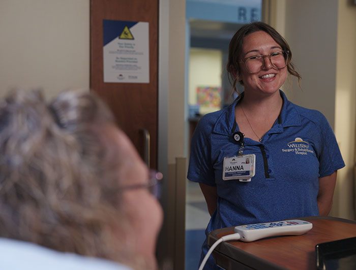 A happy smiling WellSpan female nurse checking in on patient
