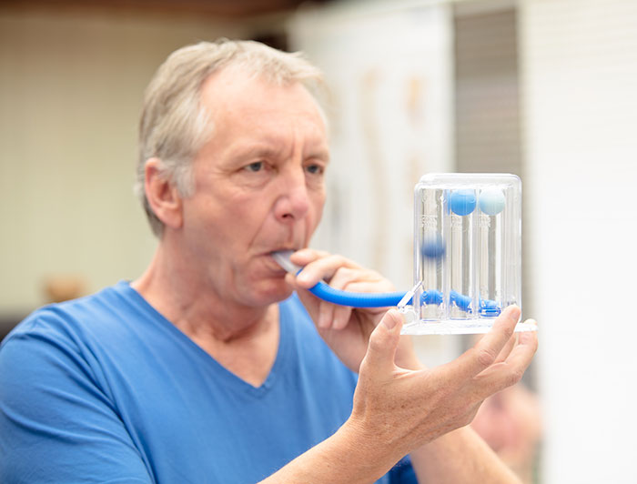 Texas Health Harris Methodist Hospital Stephenville. Stock photo of an older man blowing into a tube