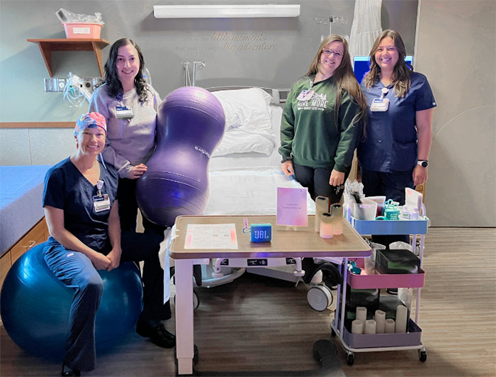 Telling the Hospital Story: Logan Health Customizing the birth experience through Labor of Love Cart. Logan Health labor and delivery staff pose in a delivery room