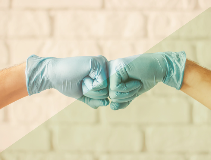 Fistbump of two hands wearing medical gloves