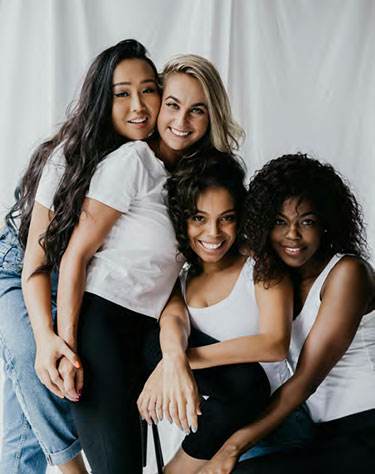 A group of four females together with smiles