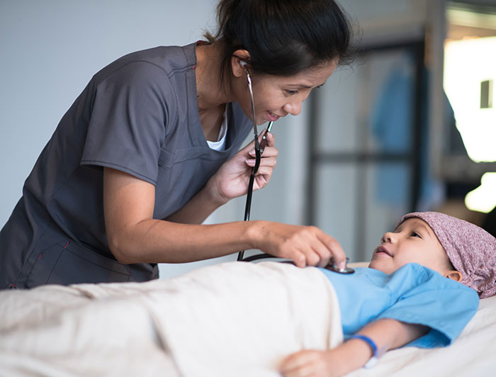 Telling the Hospital Story: Healing comes full circle at Loma Linda University Children’s Health; A female physician checks listens to a pediatric cancer patients heart with a stethoscope
