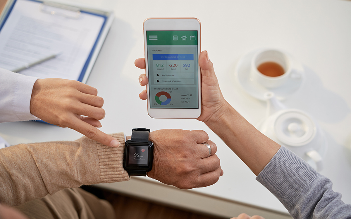 3 Ways to Engage Today’s Health Consumers. A clinician, a patient, and a patient's family member compare results from the patient's wearable medical device and a data on a mobile phone telemedicine app.