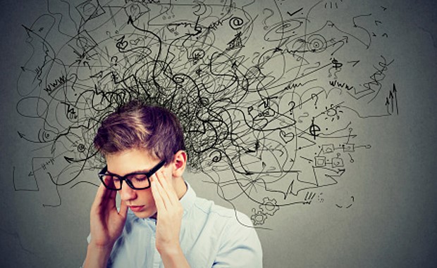 Surge in Demand for Pediatric Behavioral Health Services Fuels Funding for Startup Brightline. A young man with glasses has his hands on his temples as black squiggly lines representing his thoughts rise above his head.