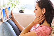 A health care user talks to her primary doctor on her tablet from home using MDLIVE