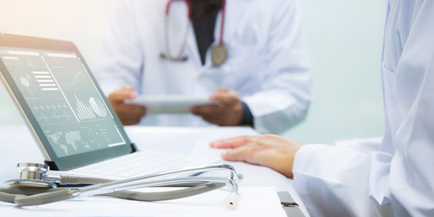 Two doctors working on a computer using AI to care for patients