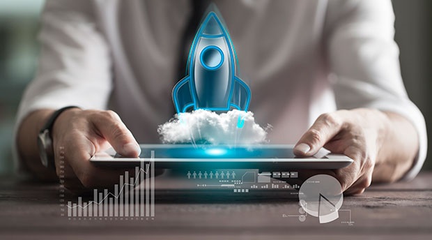 Global Digital Health Startup Activity Near All-time High. A person holds a tablet horizontally will a rocket launches from its surface and data is displayed.