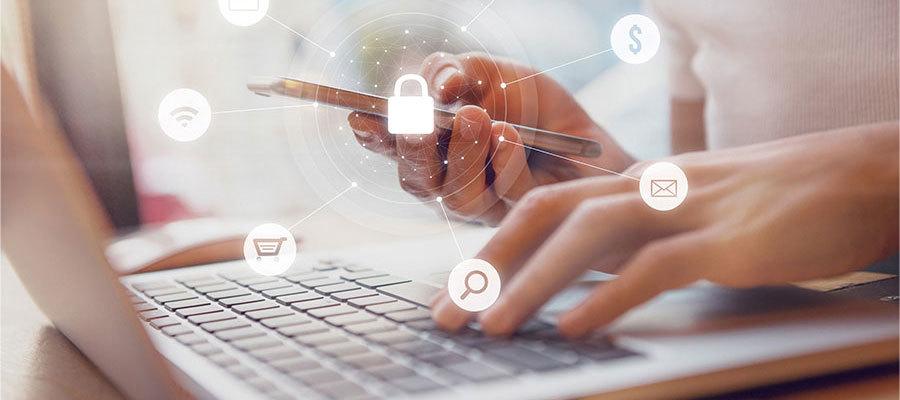 Symantic cyberattack. A woman typing on a laptop and on her mobile phone responding to a cyberattack.