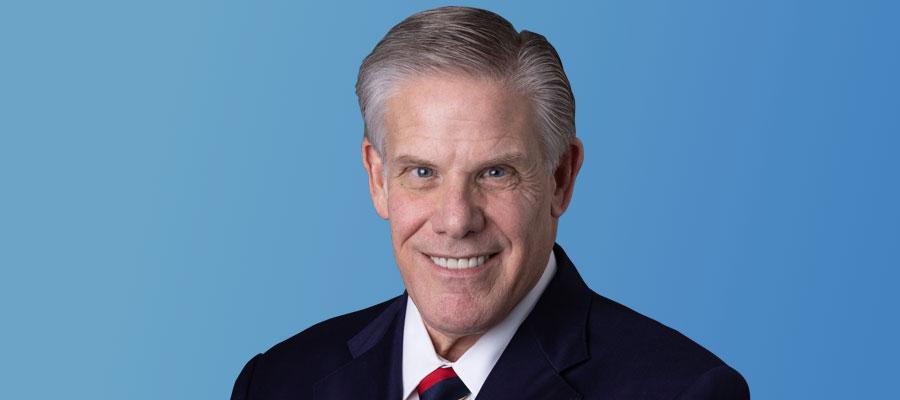 Rick-Pollack-smiling-at-camera-with-blue-background