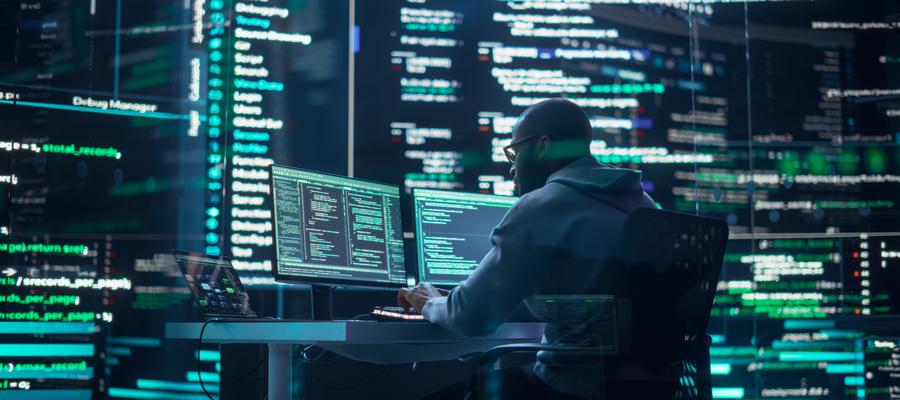 Man at computer looking at computer code.