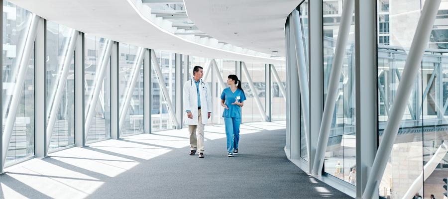 Health care workers stroll through a modern facility