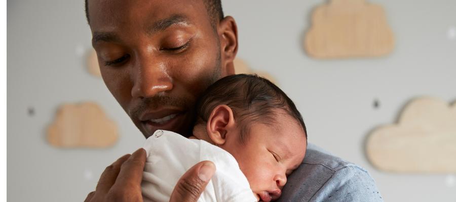 A Black father holds his infant