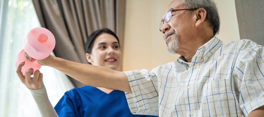 Man exercising with weight plus therapist