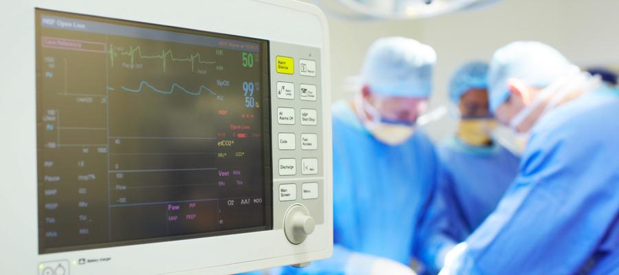 Cardiologists attend patient with monitor showing vitals