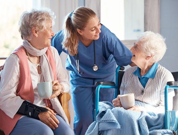 Older women having coffee speak with young female health worker