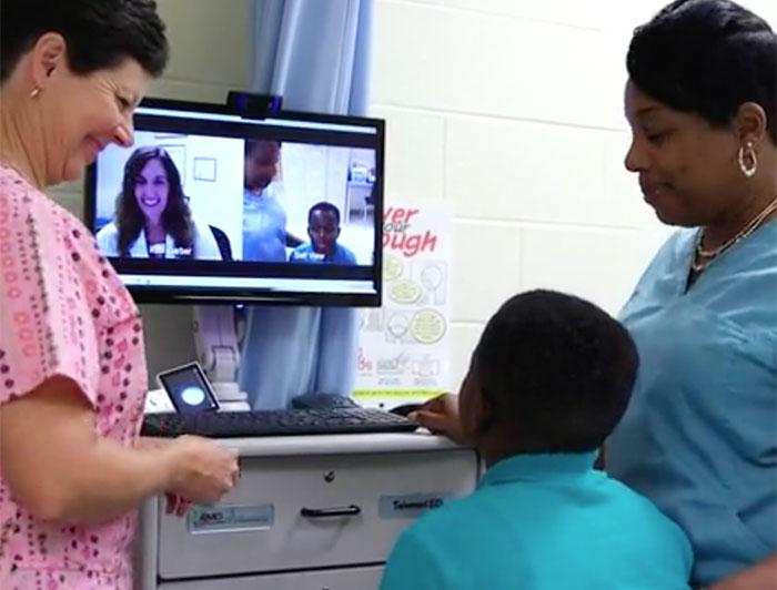 A nurse assists a boy and his mother who are talking with a doctor via a telehealth system at MUSC in Charleston, South Carolina.