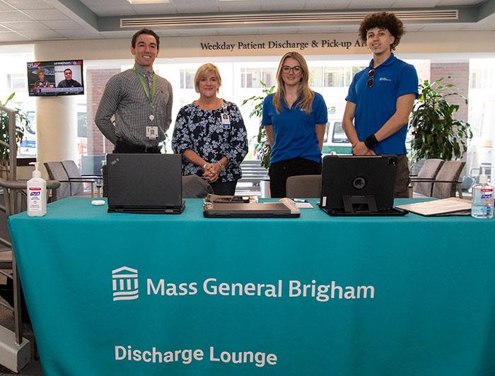 MGB staff stand at the discharge lounge welcome table