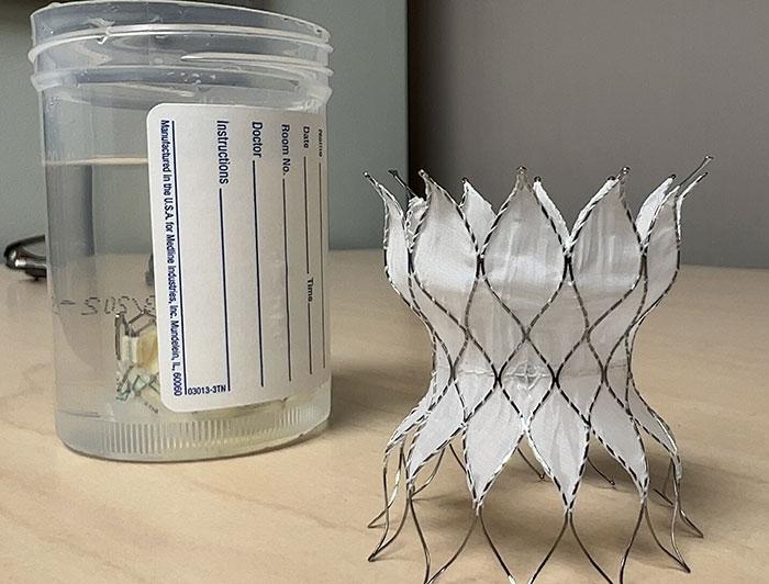 A valve is shown on a counter next to a specimen cup