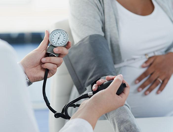 Clinician measures pregnant patient's blood pressure