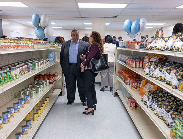 Man and woman stand in store aisle flanked by balloons