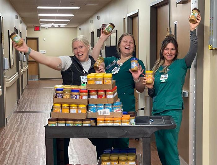 Mat-Su Regional staff pose with cases of peanut butter
