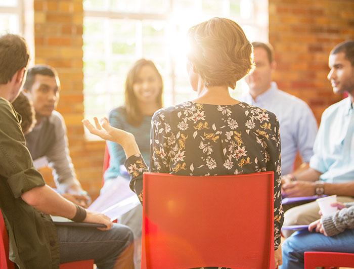 Stock photo of young adults sitting in a circle talking