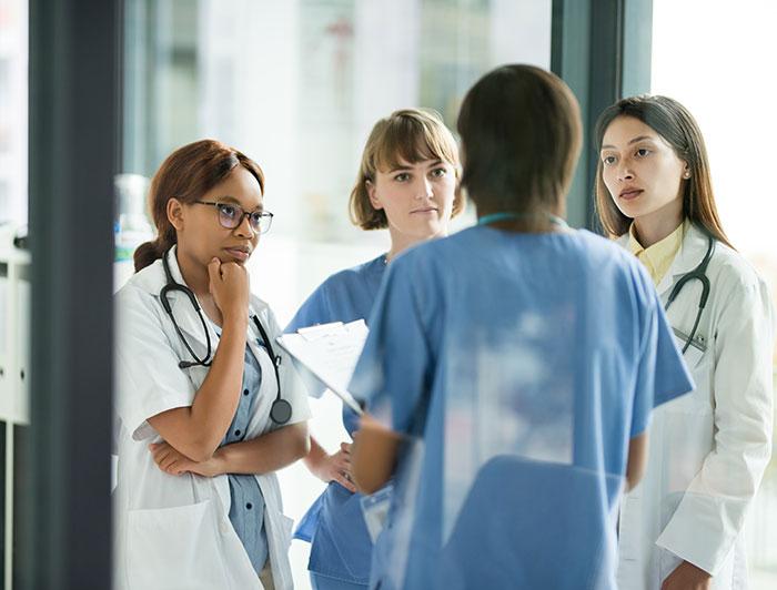 Stock image of 4 female clinicians in conversation
