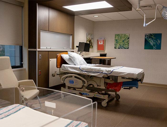 photo of birth room, hospital bed in background with bassinet in foreground