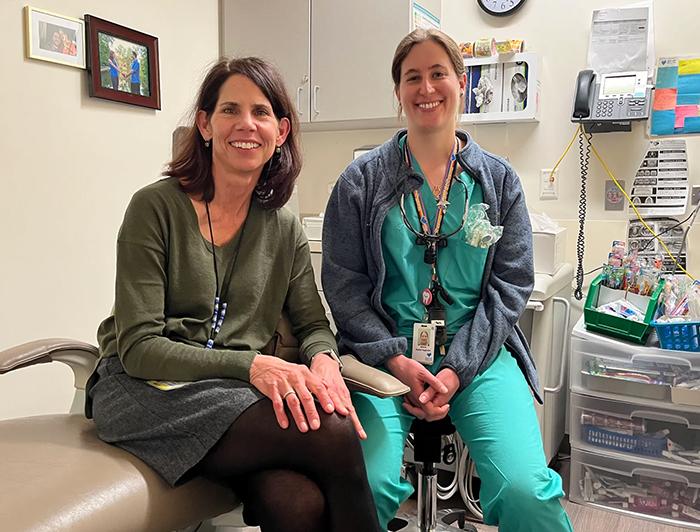 Denver Health clinicians sit smiling in a patient room