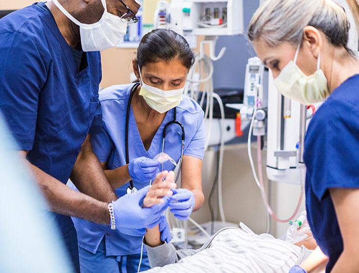 Three Clinicians tend to a trauma patient