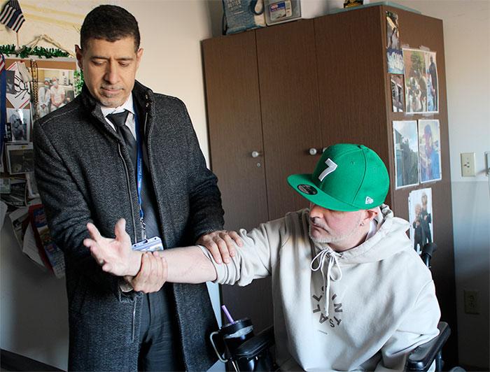 Eitan Melamed, M.D., chief of hand surgery at NYC Health + Hospitals, check's Harry Perks' right hand