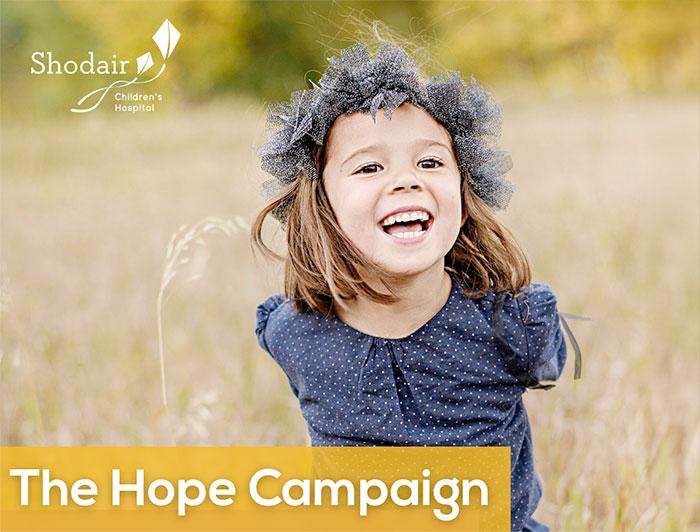Shodair - The Hope Campaign ad features a young girl, smiling in a field of tall grass