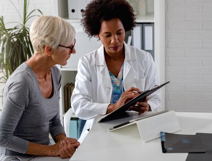 Baptist Health UAMS Utilizes New Therapy to Treat Obstructive Sleep Apnea. A clinician reviews information on a clipboard with a patient suffering from experiencing obstructive sleep apnea.