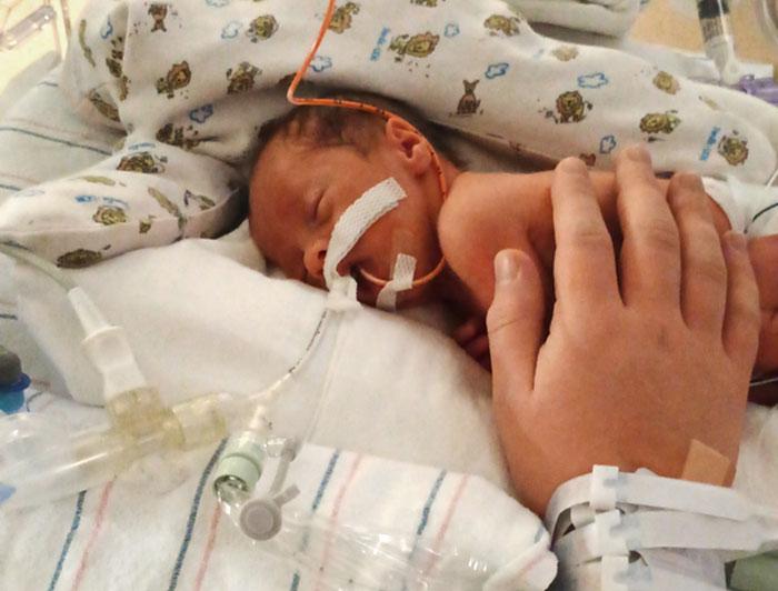 One of the Vargas quadruplet rests in a bassinet