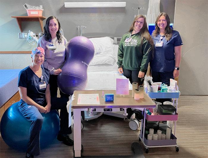 Logan Health labor and delivery staff pose for a photo in a delivery room 