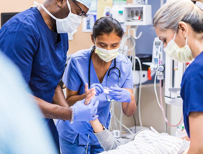 three health workers training in a triage bay